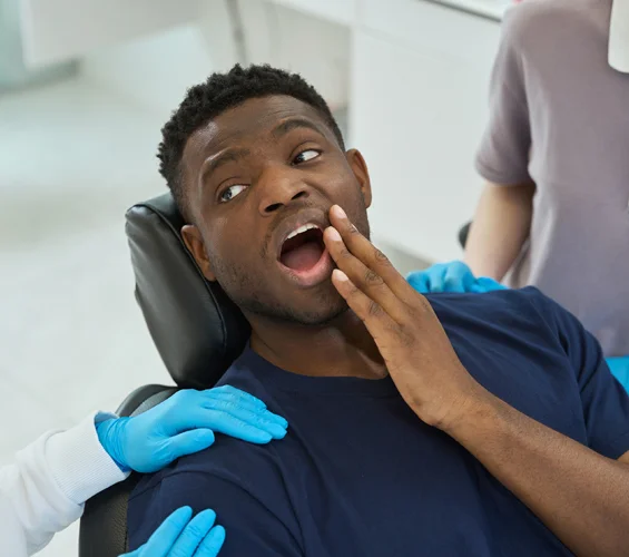 A man visit a dental office in Phoenix with tooth pain and an emergency dentist ready to treat him