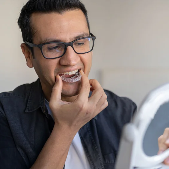 a man holding a Invisalign aligners at dental office in Phoenix