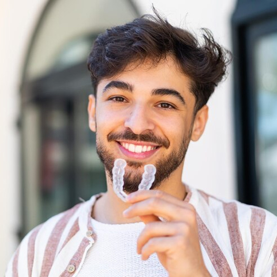 A young men showing Invisalign Aligners in Phoenix